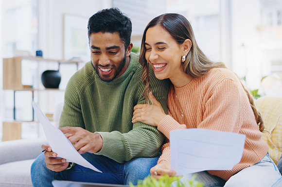 couple looking at paperwork and smiling