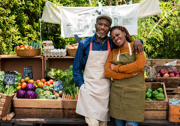 couple in front of their farmers market booth