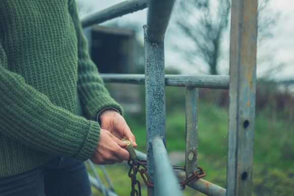 woman locking a metal gate