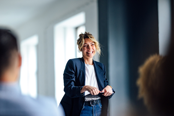woman standing in front of people holding a tablet
