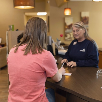 Student at teller line completing transaction with banker