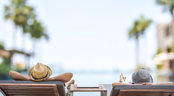 two people in lounge chairs overlooking the ocean