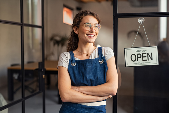 shop owner in doorway next to Open sign