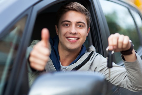 guy in a car holding out a thumbs up and car keys
